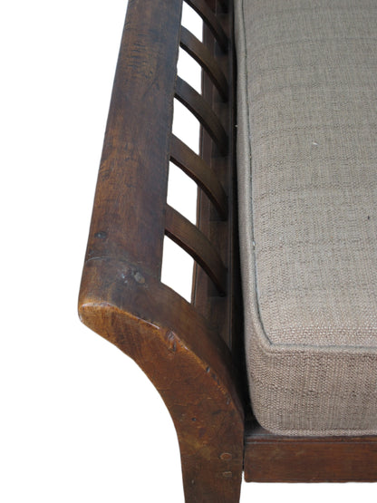 Close-up of a wooden chair with a gray cushion on a white background