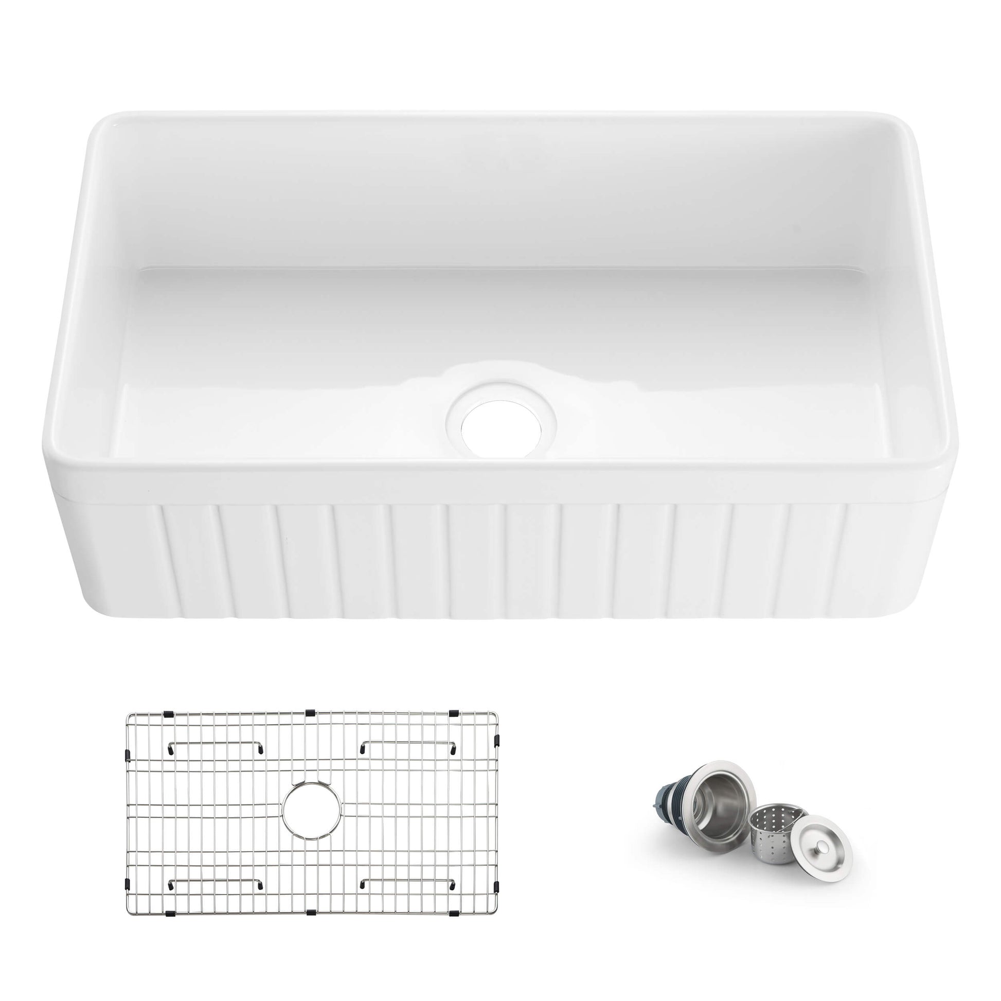 White kitchen sink with grid and drain assembly on a white background