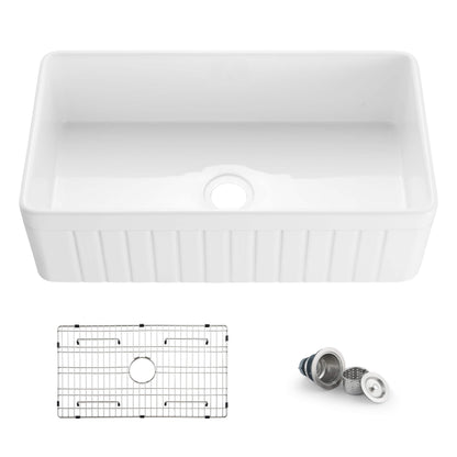 White kitchen sink with grid and drain assembly on a white background