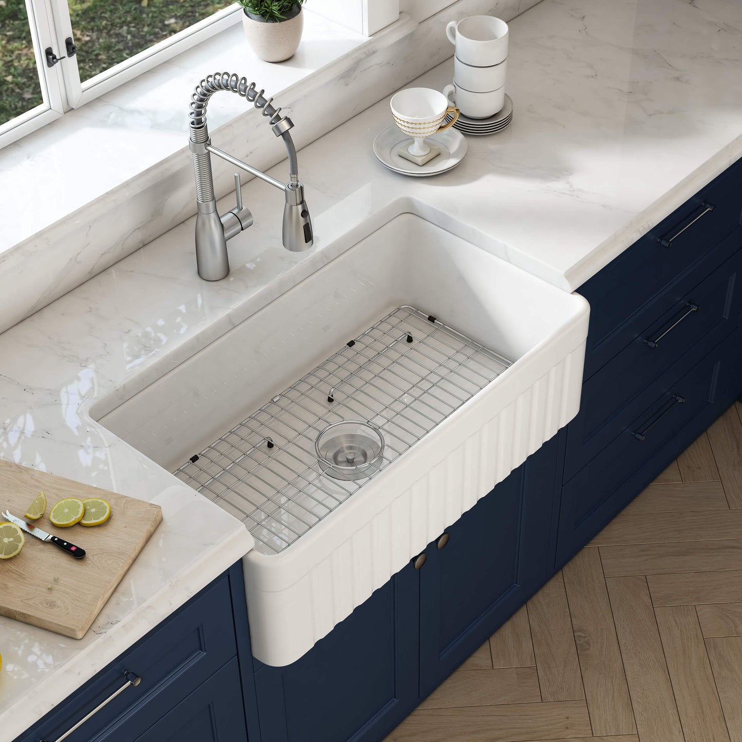 White kitchen sink with blue cabinets and a window in the background