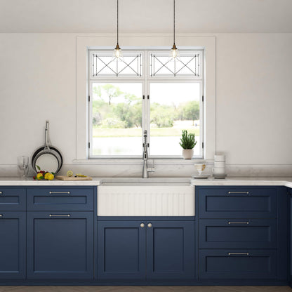 Modern kitchen with blue cabinets, white sink, and window view.