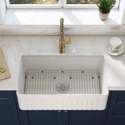 White kitchen sink with gold faucet in a modern kitchen setting