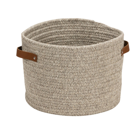 Beige woven basket with leather handles on a white background