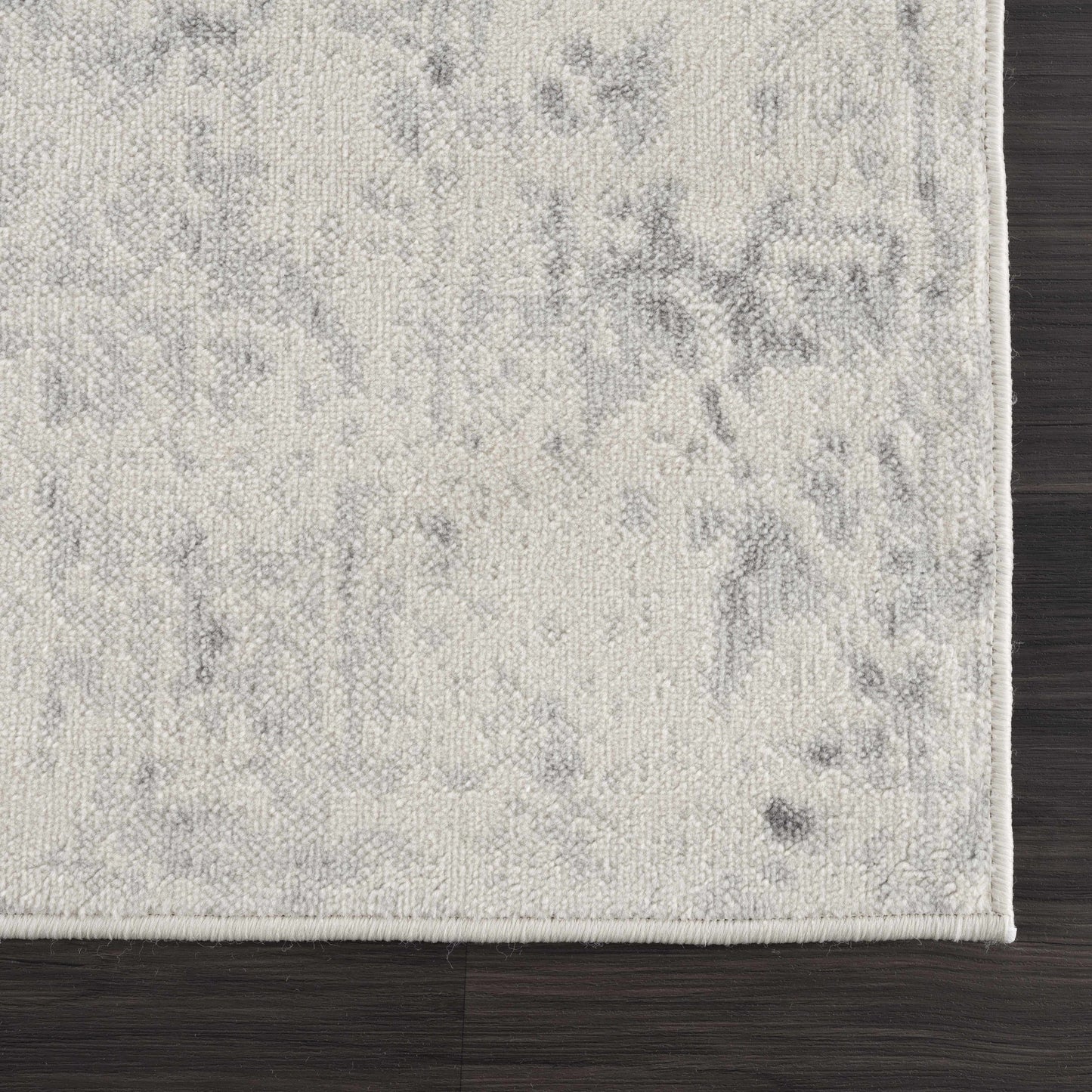 Close-up of a textured gray rug on a wooden floor