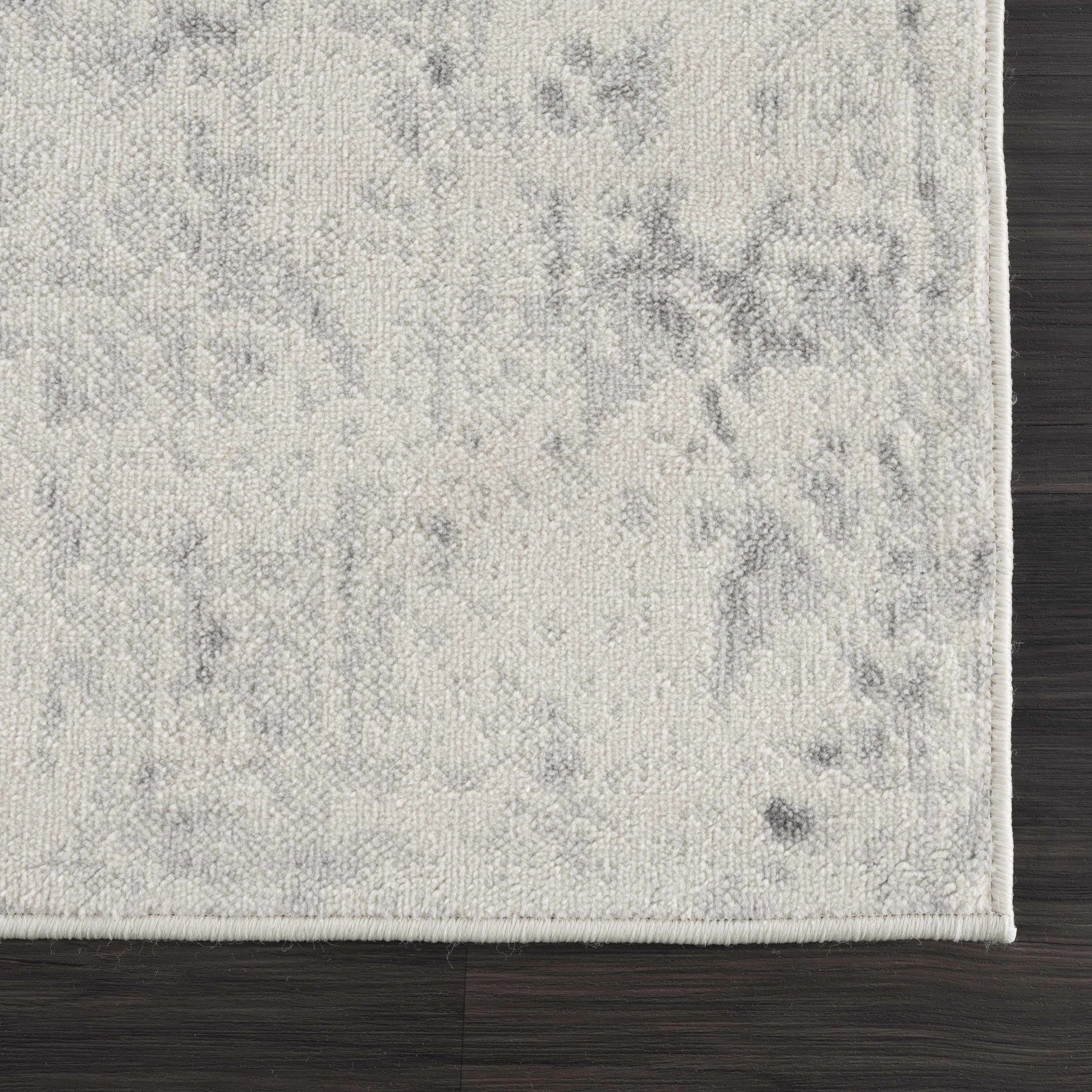 Close-up of a textured gray rug on a wooden floor