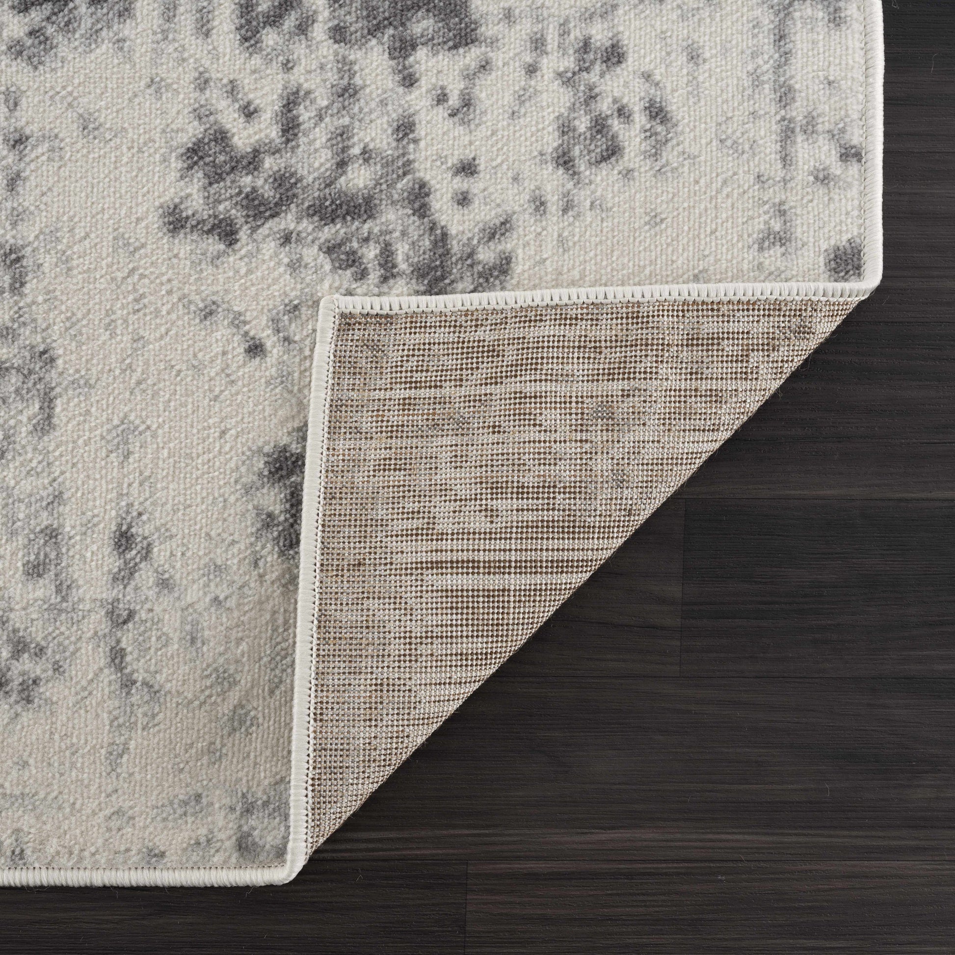 Close-up of a textured rug corner on a wooden floor
