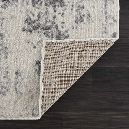 Close-up of a textured rug corner on a wooden floor