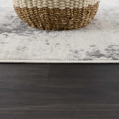 Close-up of a textured rug with a woven basket on a wooden floor.