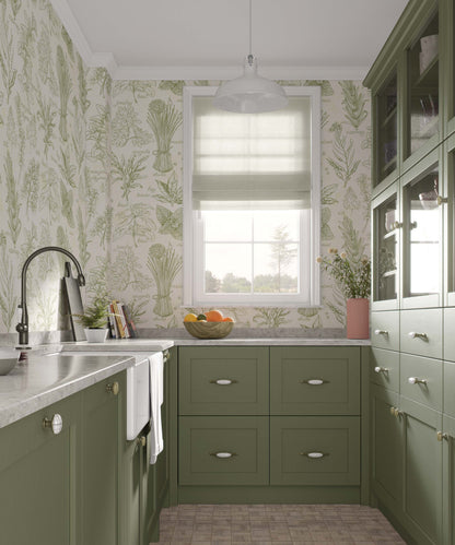 A kitchen with green cabinetry and floral wallpaper featuring images of herbs and greenery.