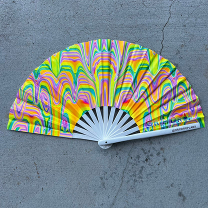 Colorful hand fan with a pattern on a gray surface