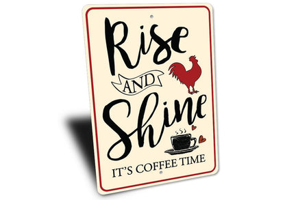 Decorative sign with text 'Rise and Shine, It's Coffee Time' featuring a rooster and coffee cup on a white background.