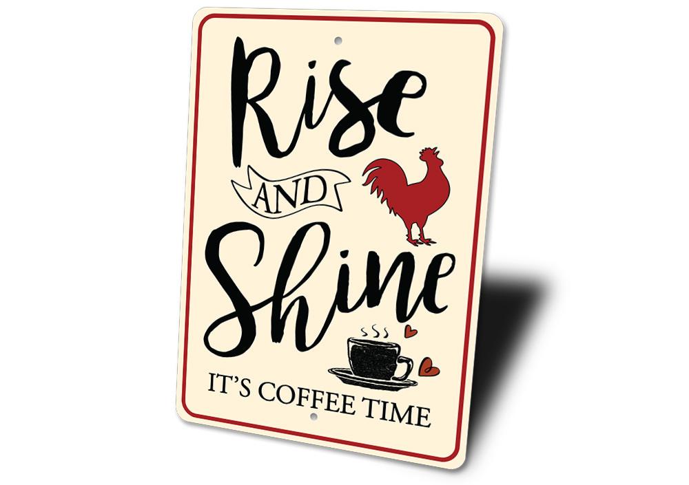 Decorative sign with 'Rise and Shine, It's Coffee Time' text and a rooster illustration on a white background.