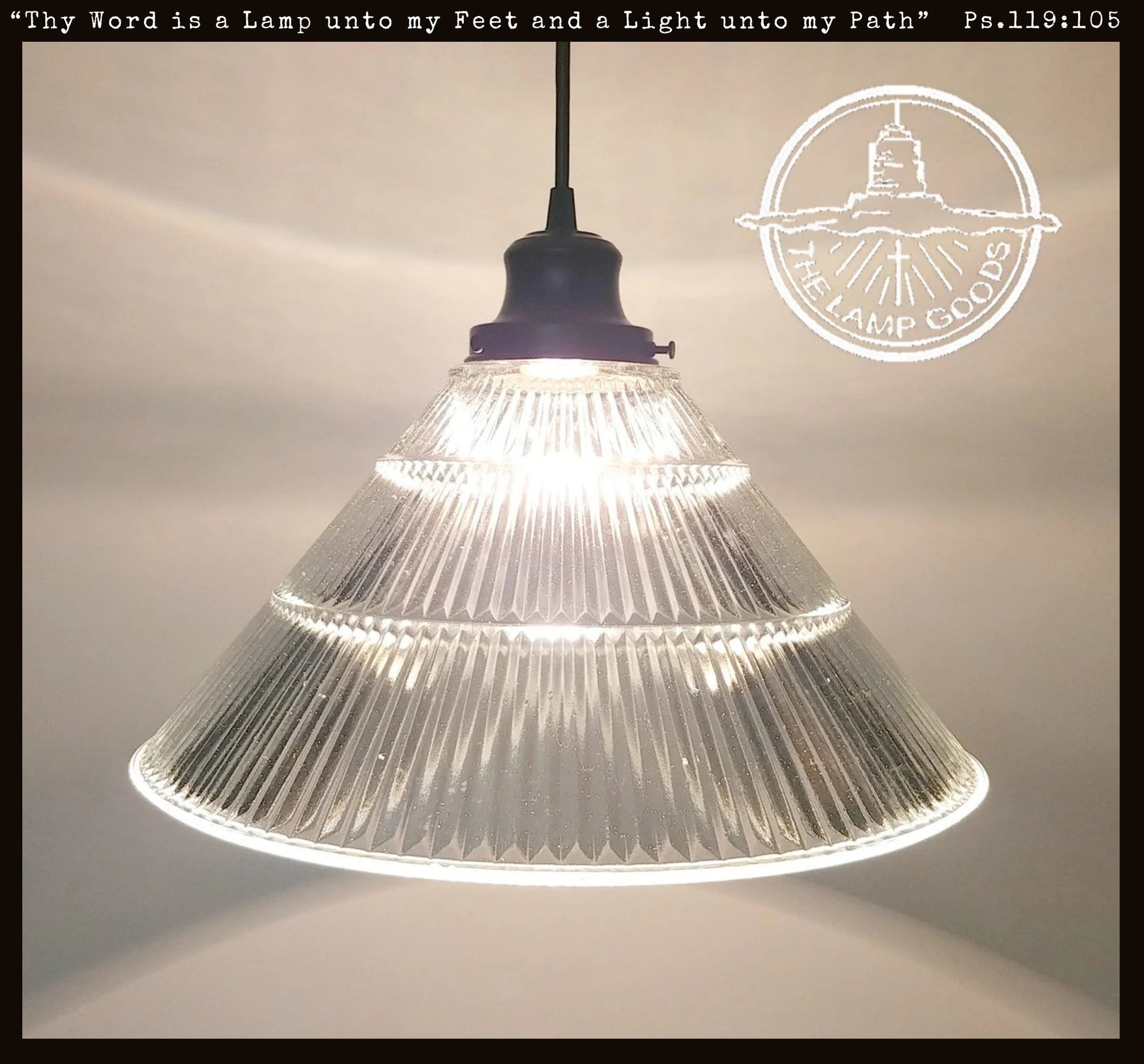 Clear glass pendant light with text and logo on a neutral background