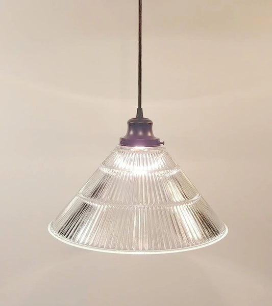 Clear glass pendant light with ribbed design on a beige background