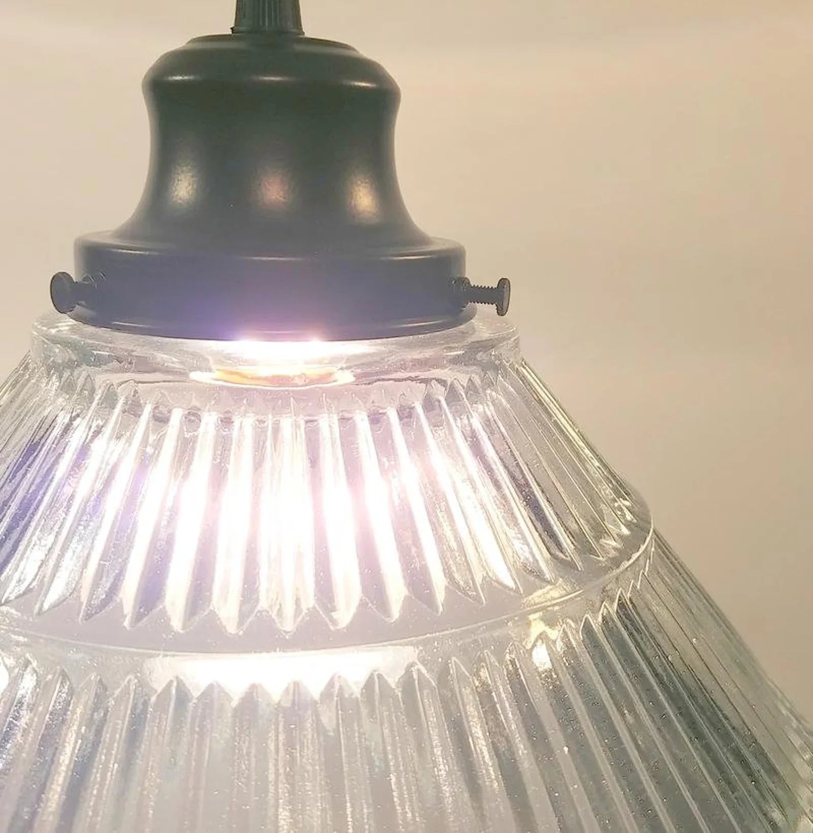 Close-up of a pendant light with ribbed glass shade and black metal fixture.