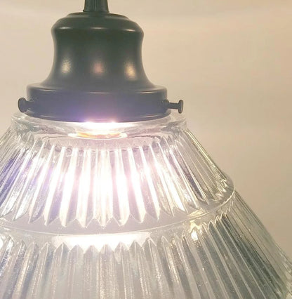 Close-up of a pendant light with ribbed glass shade and black metal fixture.