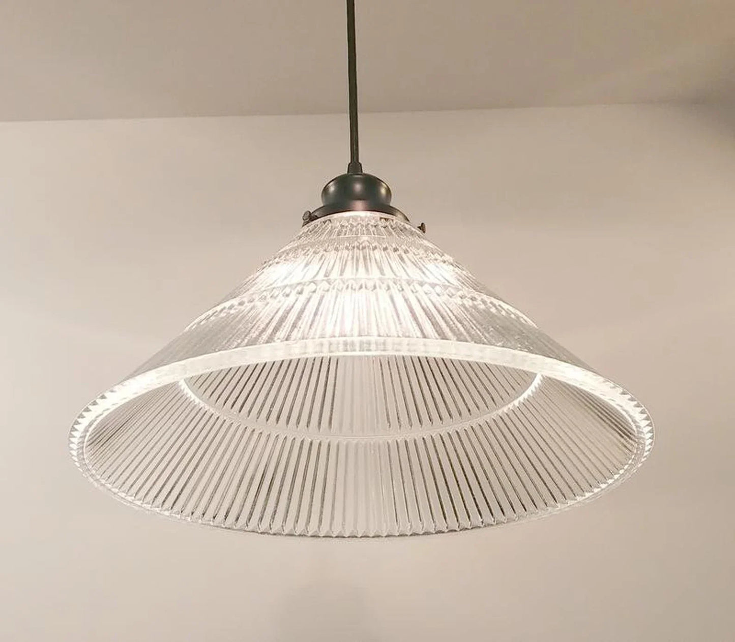 Clear glass pendant light fixture on a neutral background