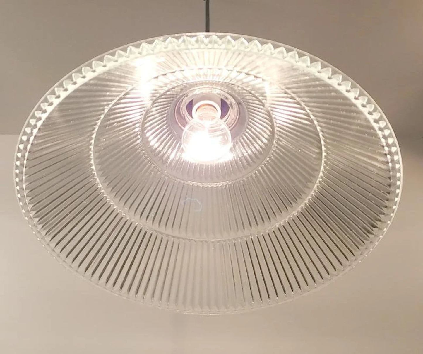 Clear glass ceiling light fixture on a neutral background
