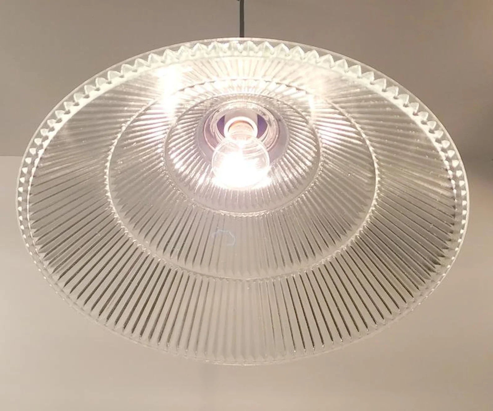 Clear glass ceiling light fixture on a neutral background
