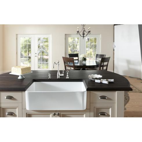 White farmhouse sink in a modern kitchen with dark countertops and neutral walls.