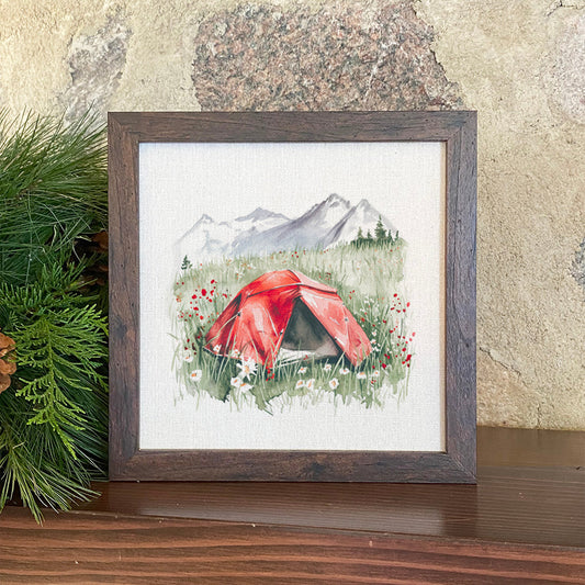 Framed artwork of a red tent in a mountainous landscape with flowers.