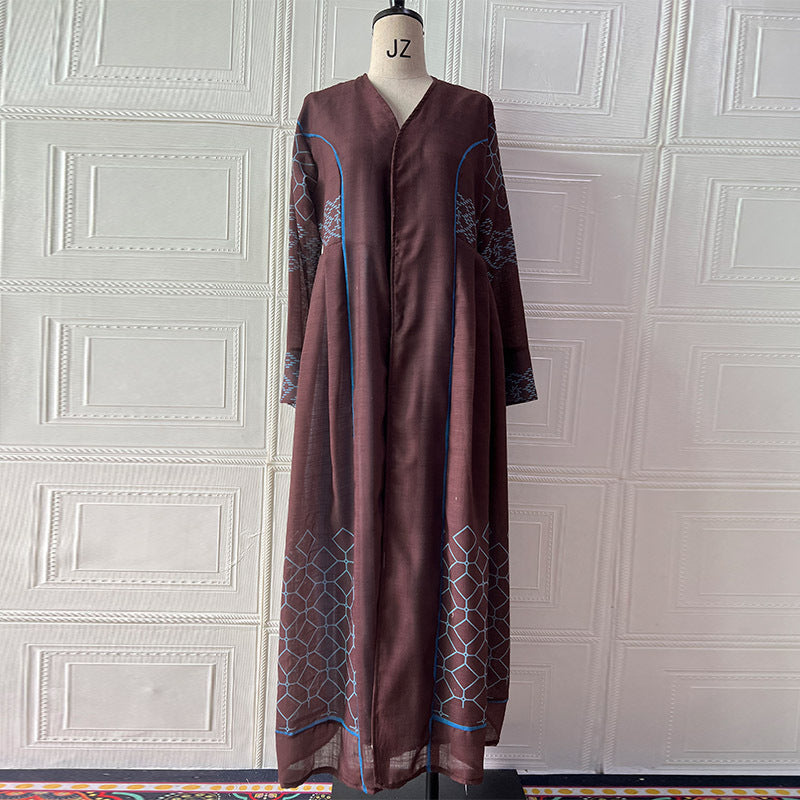 Brown dress with geometric patterns on a mannequin against a white paneled wall.