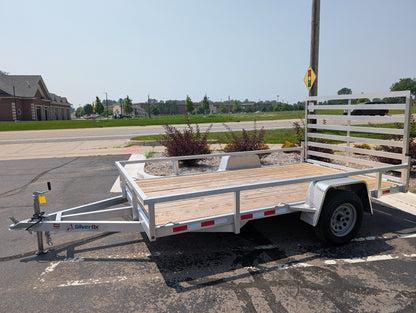 White utility trailer with wooden floor on a paved road