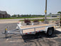 White utility trailer with wooden floor on a paved road