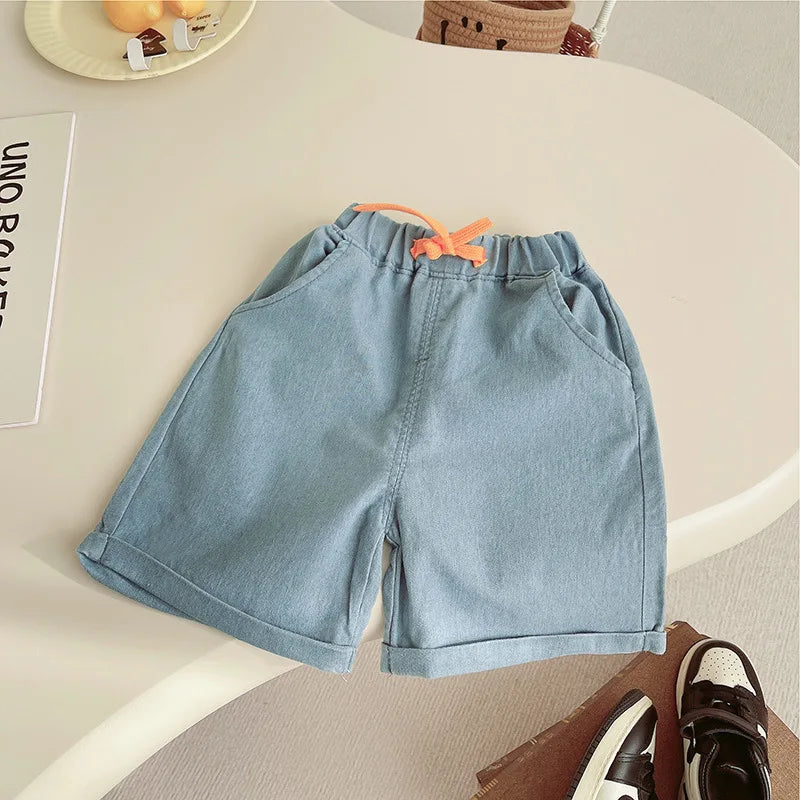 Light blue denim shorts on a white surface with a neutral background