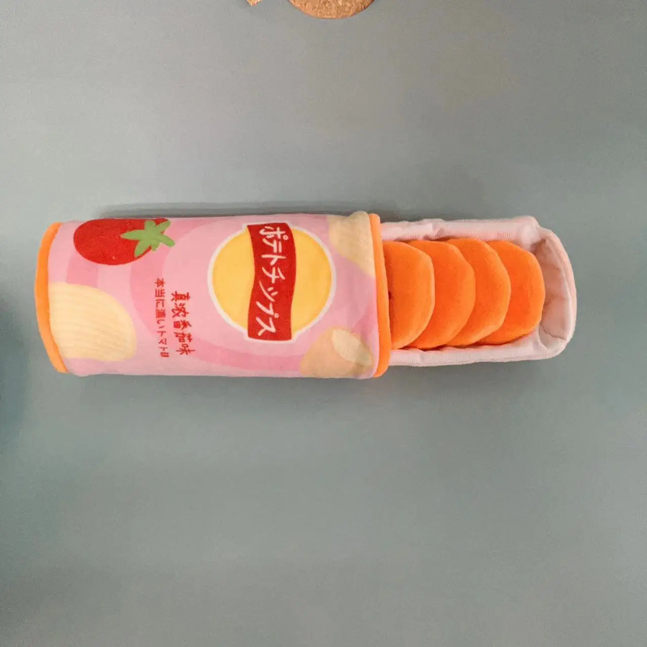 Roll of orange wipes with a pink container on a gray background