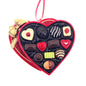 Heart-shaped chocolate box with various chocolates and a gold bow on a white background