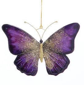 Decorative butterfly ornament with purple and gold wings on a white background