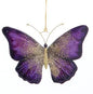 Decorative butterfly ornament with purple and gold wings on a white background