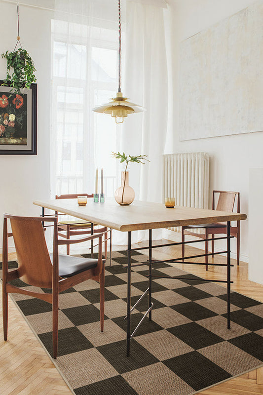 Dining room with wooden table and chairs on a checkered rug