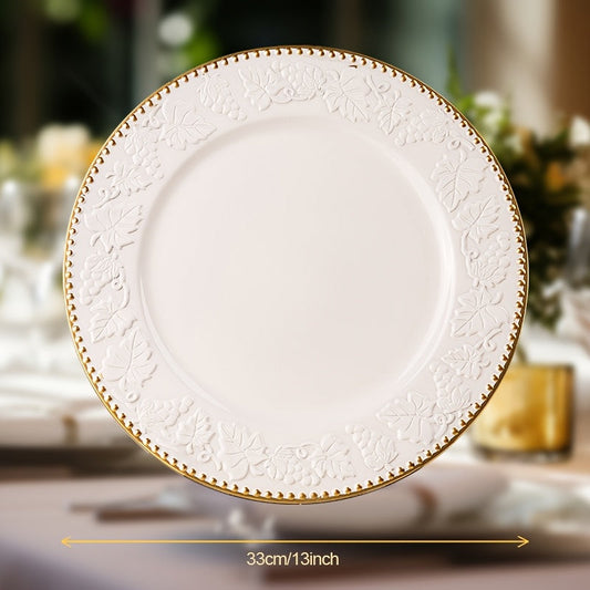 A white and gold decorative charger plate with an intricate floral pattern around the edge, measuring 33 cm (13 inches).