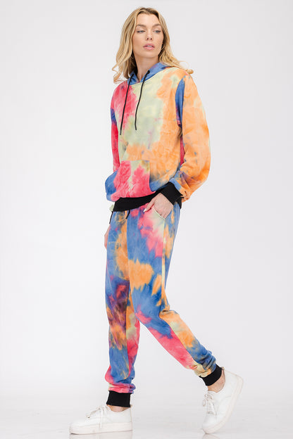 Person wearing a colorful tie-dye onesie on a white background