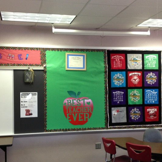 Classroom bulletin board with 'Best Teacher Ever' sign and various posters.