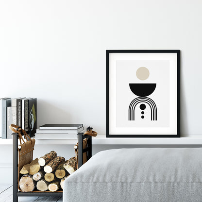 Framed abstract art print on a wall above a bed with books and firewood below.