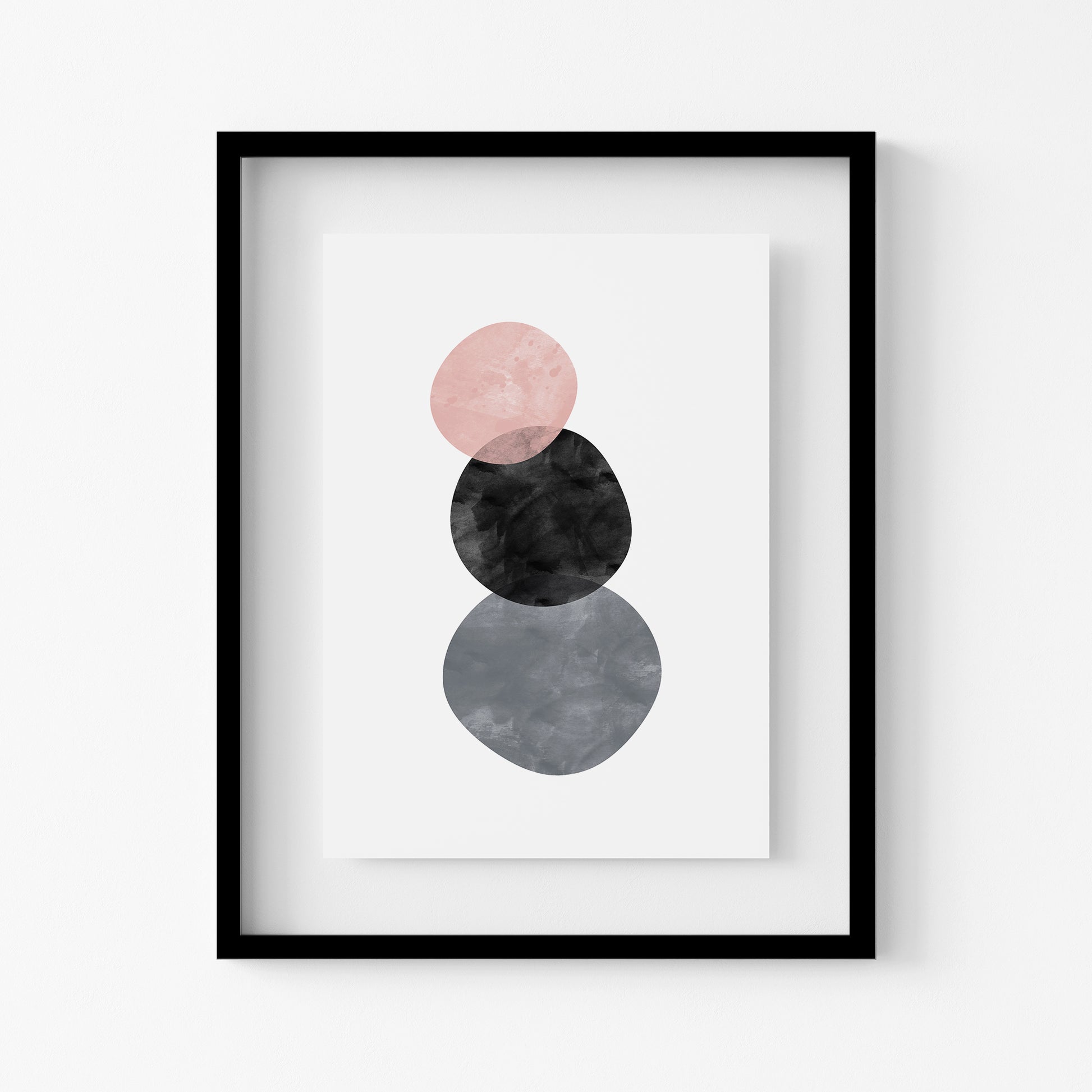 Framed abstract art print with pink, black, and gray circles on a white background