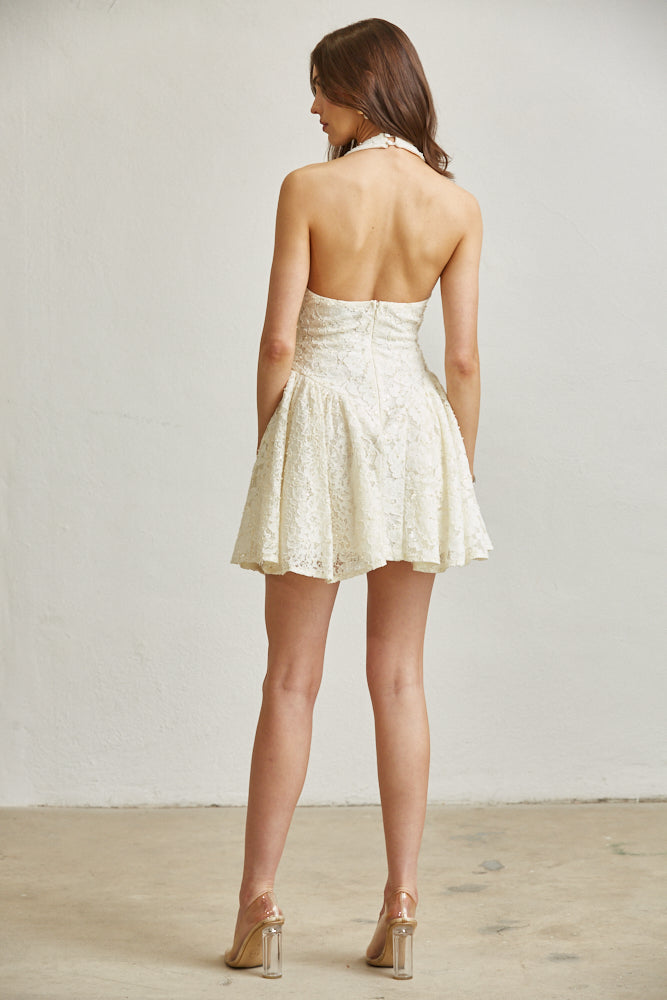 Woman wearing a white lace dress with a plain background