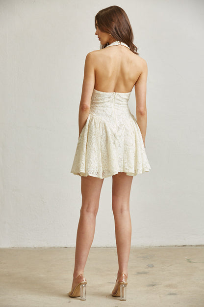 Woman wearing a white lace dress with a plain background