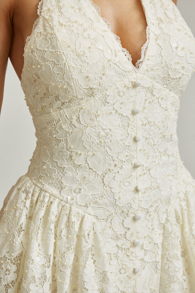Close-up of a white lace dress with a blurred background
