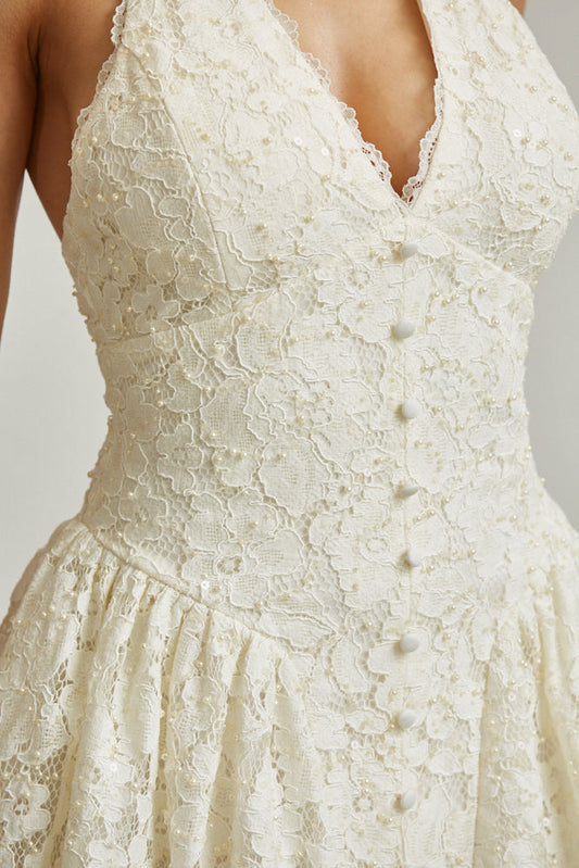 Close-up of a white lace dress with a blurred background