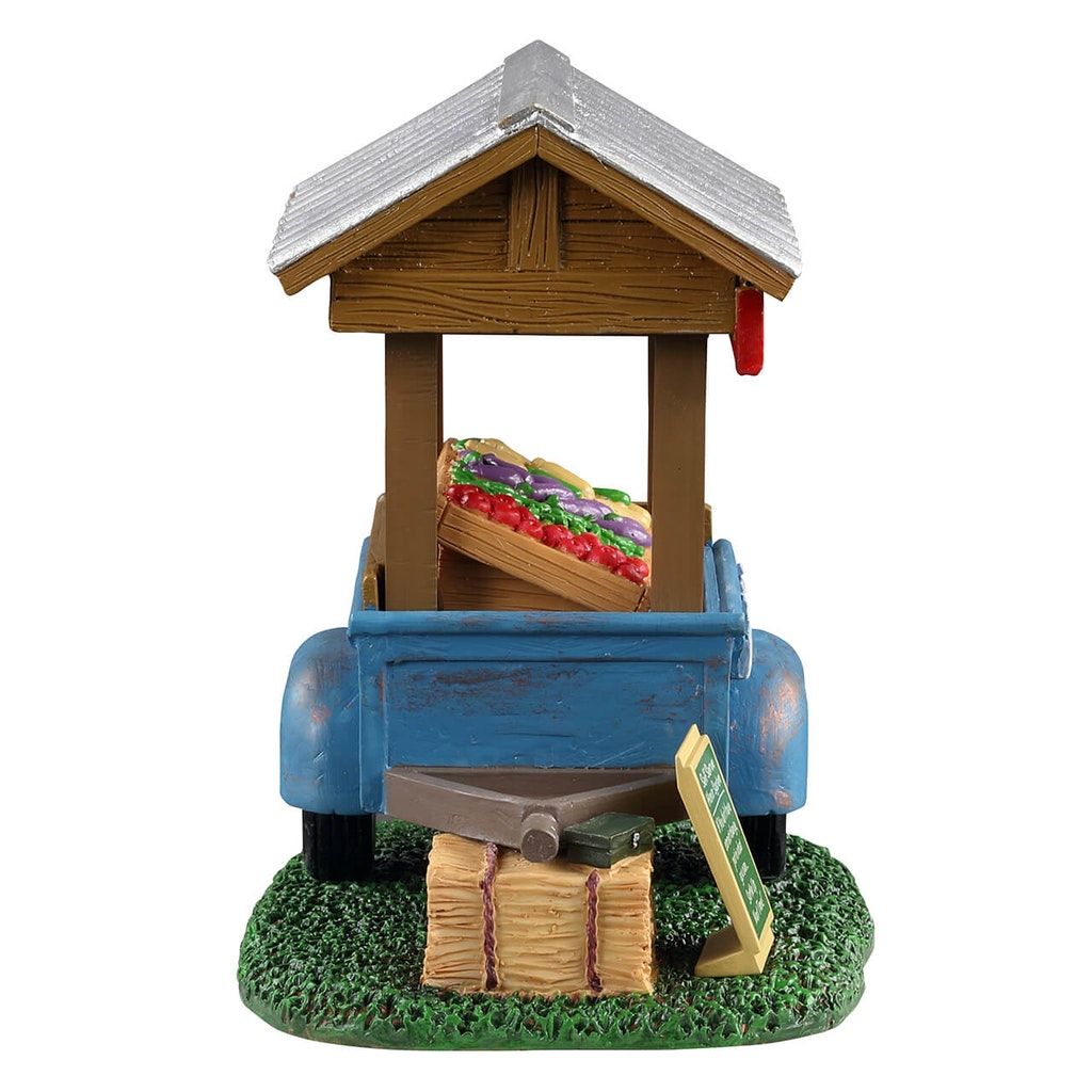 Model of a blue truck with a wooden structure and vegetables on a white background