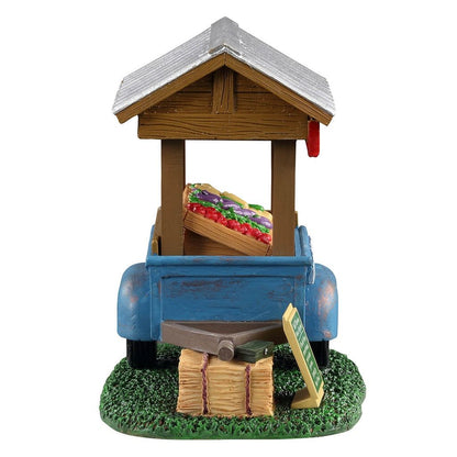 Model of a blue truck with a wooden structure and vegetables on a white background