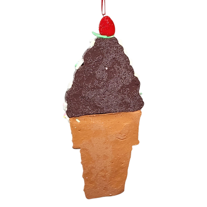 Decorative ice cream cone ornament with chocolate ice cream and cherry on top against a white background
