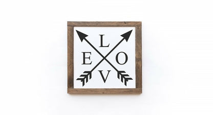 Decorative sign with crossed arrows and 'LOVE' on a white background