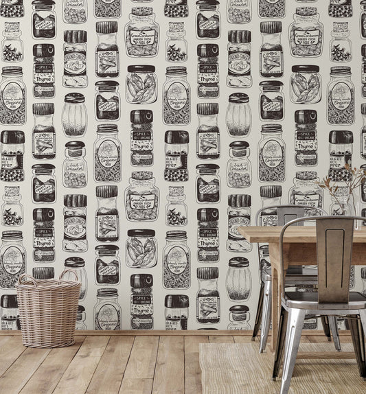 A section of wallpaper with a vintage spice rack design, featuring black and white illustrations of various herbs and spices, displayed in a room setting with a table and chairs.