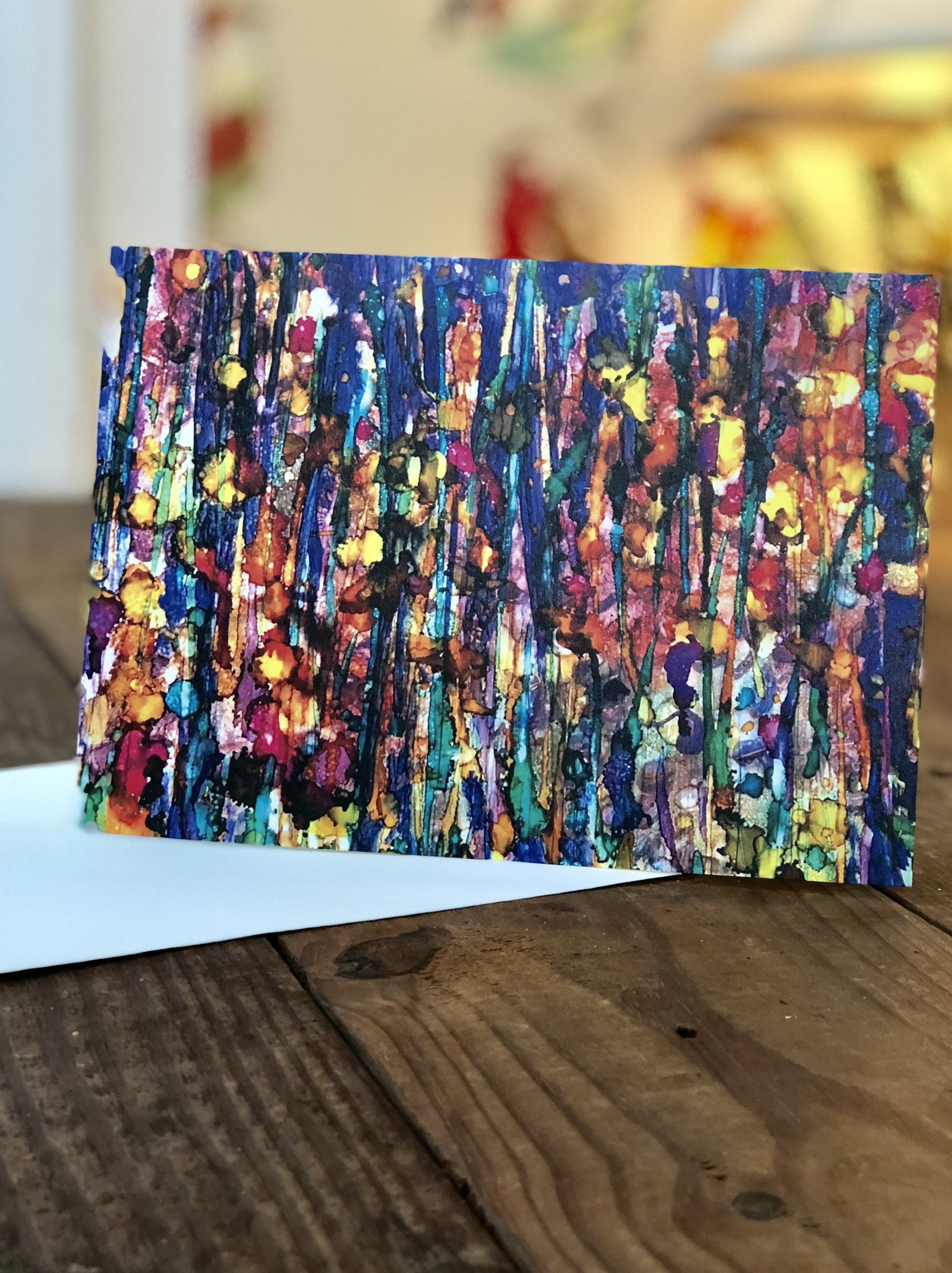 Colorful abstract painting on a wooden surface with a blurred background