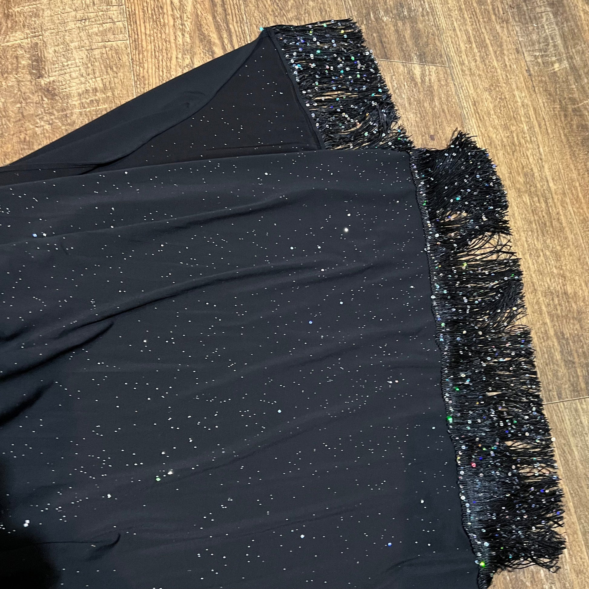 Black fabric with star pattern and decorative trim on a wooden surface